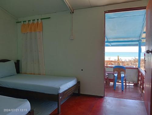 a bedroom with a bed and a balcony with a table at Homestay Nom Kamil in Tiga Papan