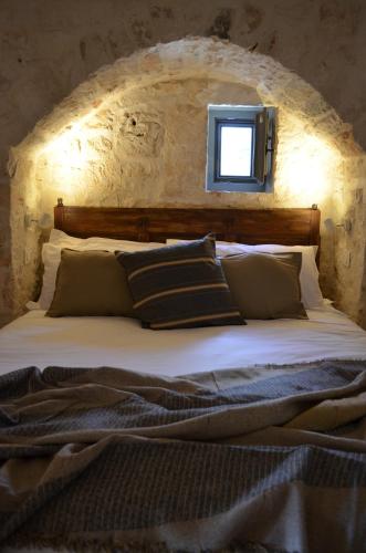 ein Schlafzimmer mit einem Bett und einem Fenster darüber in der Unterkunft B&B Fuga al Trullo in Ostuni