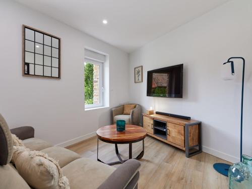 un salon avec un canapé et une table dans l'établissement Holiday Home La Bergerie by Interhome, à Créances