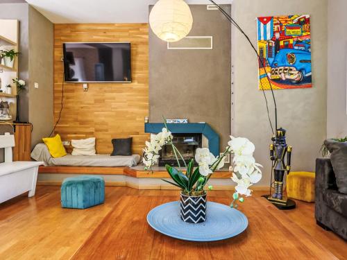 a living room with a couch and a table with flowers at Holiday Home Maison de Locmaria by Interhome in Ploemel