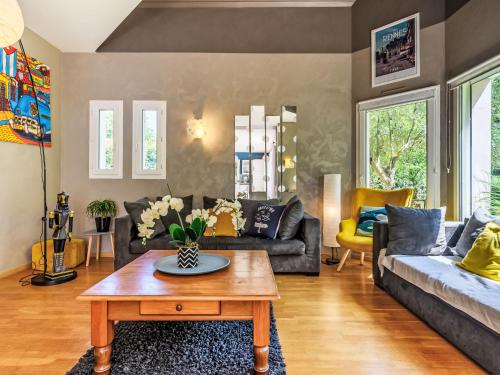 a living room with couches and a coffee table at Holiday Home Maison de Locmaria by Interhome in Ploemel