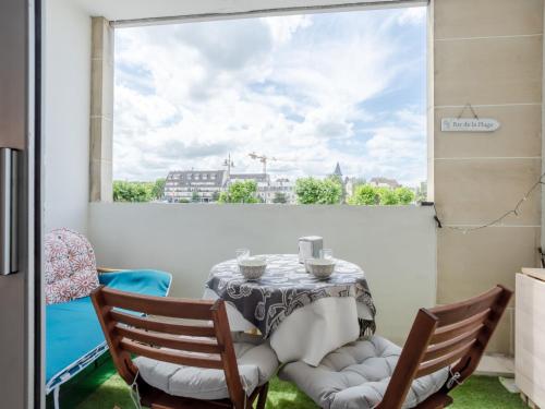 une table et des chaises dans une pièce avec une fenêtre dans l'établissement Studio Port Trouville by Interhome, à Trouville-sur-Mer