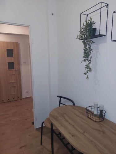 a room with a wooden table and a plant on the wall at Apartament Centrum przy Placu Zwycięstwa in Gryfice