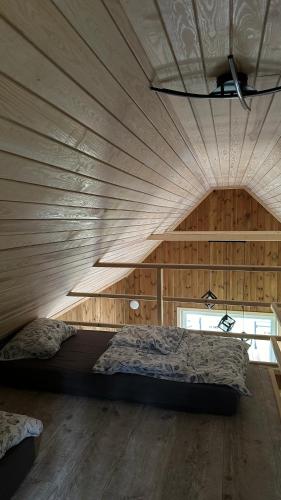a bedroom with a large bed in a wooden wall at Domek nad Uroczyskiem in Piotrowice
