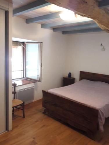 une chambre avec un lit et deux fenêtres dans l'établissement Maison type loft au coeur du village, à Simorre