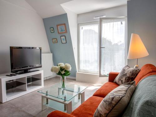 - un salon avec un canapé orange et une télévision dans l'établissement Apartment Côté Port by Interhome, à Pornic