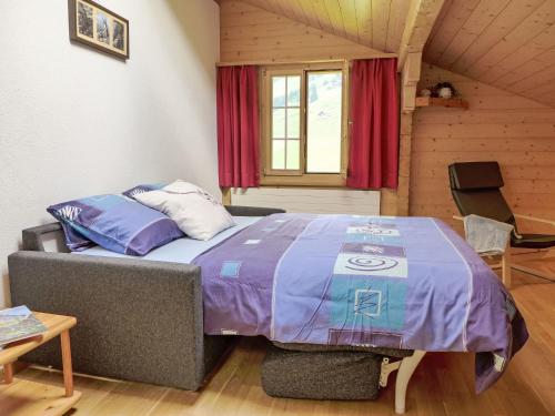 a bedroom with a bed with a purple comforter at Apartment Bühl by Interhome in Achseten