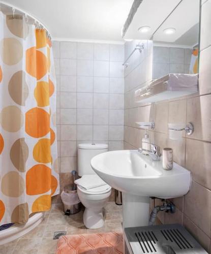 a bathroom with a white toilet and a sink at Cozy Corner near city centre in Bendevís