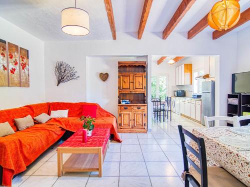 un salon avec un canapé rouge et une table dans l'établissement Holiday Home Le Mas de L'Ourmenade by Interhome, à Fayence