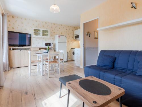un salon avec un canapé bleu et une table dans l'établissement Apartment Fleur Marine-35 by Interhome, à Cabourg