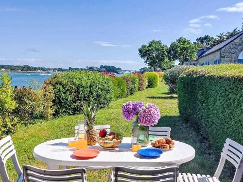 un tavolo bianco con cibo e fiori di Holiday Home La petite Pen Er Hoët by Interhome a La Trinité-sur-Mer