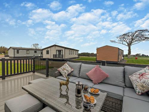 a patio with a couch and a table on a deck at 2 Bed in St Andrews 95035 in St. Andrews