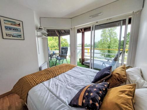 une chambre avec un lit et un balcon dans l'établissement Apartment Calme et Vue sur l'Etang au Duc by Interhome, à Vannes