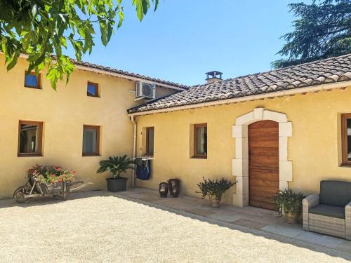une maison jaune avec une porte et une chaise dans l'établissement Apartment Le Mas des Trois Anges-4 by Interhome, à Saint-Denis