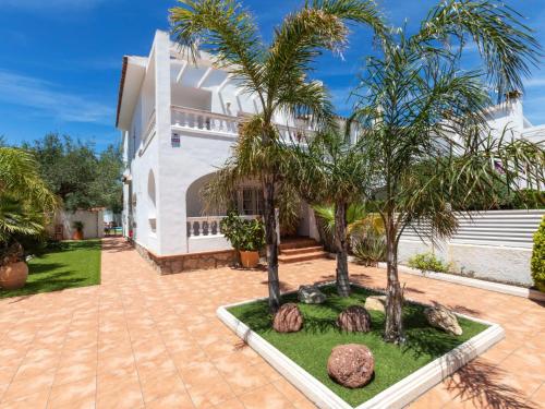 a courtyard with palm trees and a house at Holiday Home Salze by Interhome in Hospitalet de l'Infant