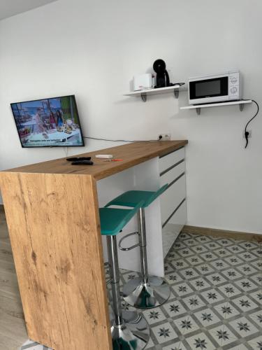 a kitchen with a desk with a microwave and a stool at Casa Rural El Almendro in Fernán Pérez