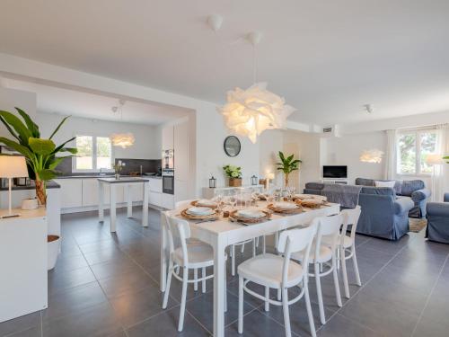 une cuisine et un salon avec une table et des chaises blanches dans l'établissement Holiday Home Villa de Stephanie by Interhome, aux Issambres
