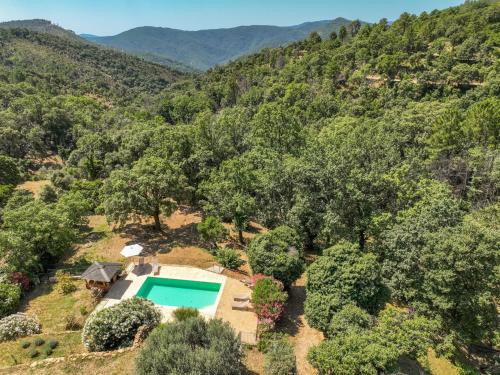 - une vue aérienne sur une villa avec une piscine dans une forêt dans l'établissement Holiday Home Les Glycines by Interhome, à La Garde-Freinet
