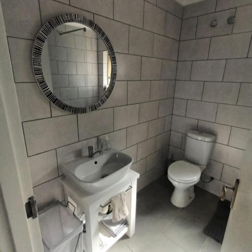 a bathroom with a sink and a toilet and a mirror at Ramsgate Beachfront - Ramsgate Palms AA 50 in Margate