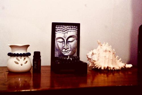 a wooden table with a statue of a head and a vase at House of Sincerity in Maharagama