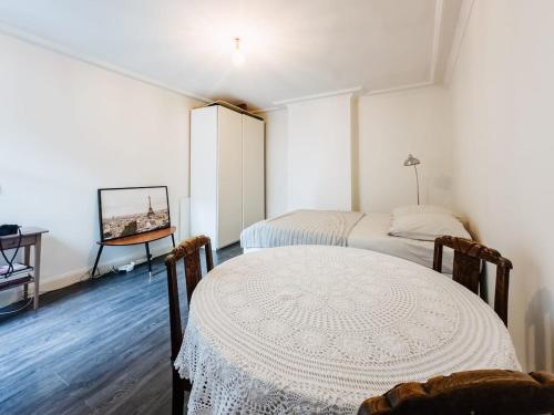 une chambre avec deux lits et une table dans l'établissement studio au calme, à Paris