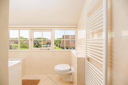 a bathroom with a toilet and a window at De Bosuil in Hoge-Hexel