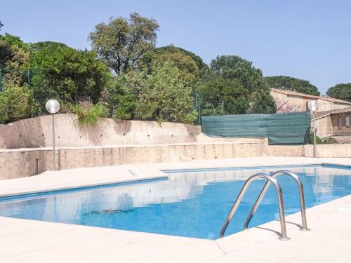 une piscine avec de l'eau bleue devant une maison dans l'établissement Holiday Home Le Hameau de Gassin by Interhome, à Gassin