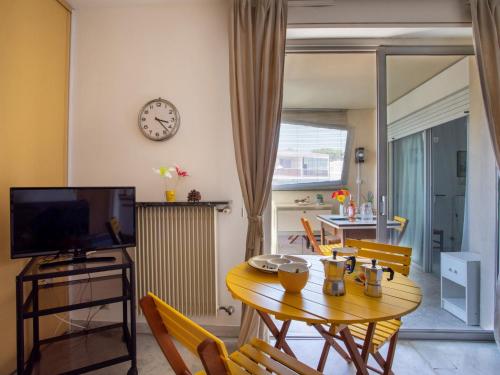 a living room with a table and a clock on the wall at Apartment Azur 3000 by Interhome in Saint-Laurent-du-Var