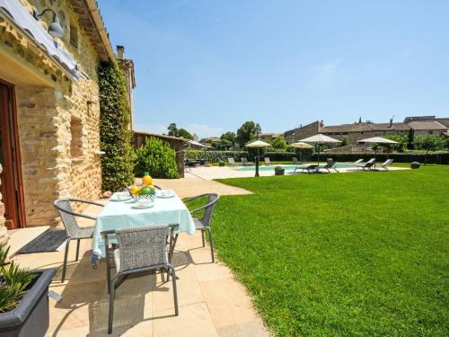 - une table et des chaises sur une terrasse avec une cour dans l'établissement Apartment Le Mas des Trois Anges-2 by Interhome, à Saint-Denis