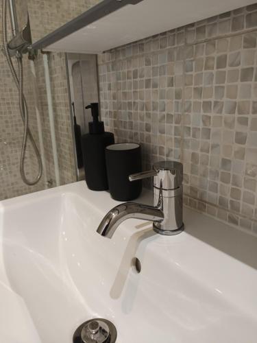 La salle de bains est pourvue d'un lavabo et d'un robinet. dans l'établissement Superbe appart à 15 min à pied du stade de France, à Aubervilliers