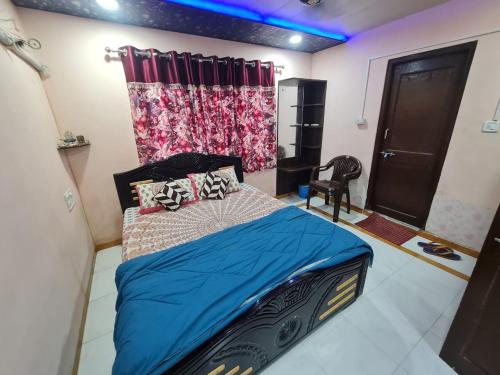 a bedroom with a bed with a blue comforter at Sabira Villa in Mount Ābu