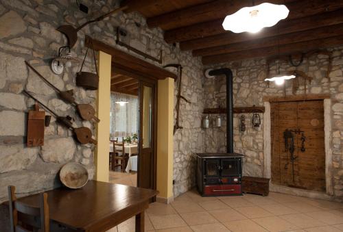 a room with a stone wall with a wood stove at Agriturismo Corte Galvani in Negrar