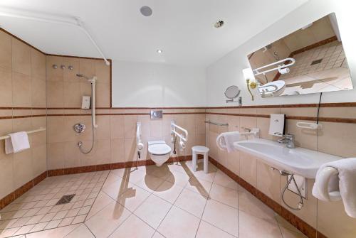 a bathroom with a toilet and a sink and a shower at Ringhotel Mönch`s Waldhotel in Unterreichenbach