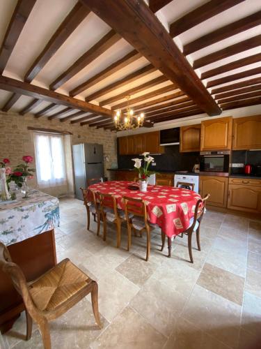 une cuisine avec une table et des chaises dans une pièce dans l'établissement Le Camp Romain, maison familiale avec terrain, à Banville