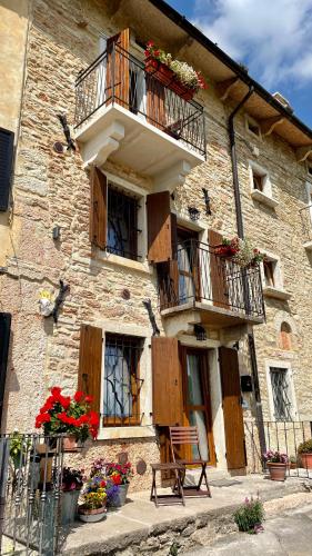 a building with a balcony and flowers on it at B&B dalla Eli in Bosco Chiesanuova