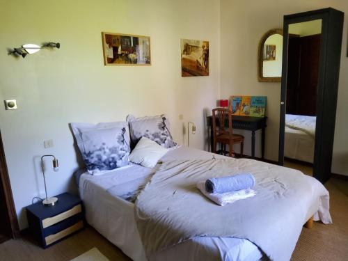 - une chambre avec un lit et une table avec un miroir dans l'établissement Villa aux pieds des alpilles, à Eygalières