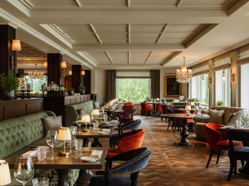 a restaurant with tables and chairs and a bar at Rosewood Schloss Fuschl in Hof bei Salzburg