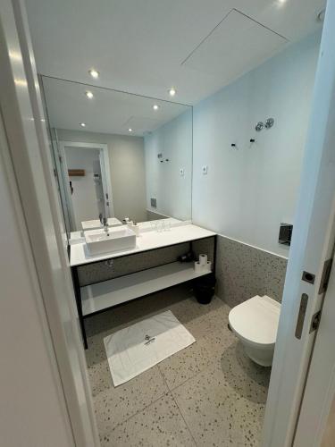 a bathroom with a sink and a toilet and a mirror at Liberator Rossio in Lisbon