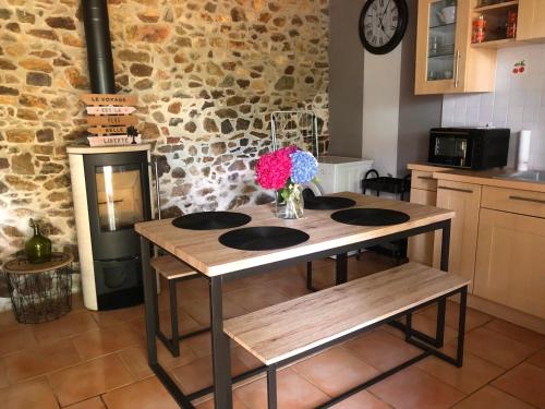 une cuisine avec une table avec un vase de fleurs dessus dans l'établissement Le TY VIAN, à Gommenec'h