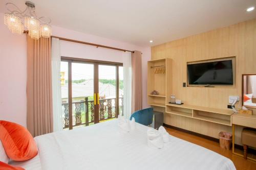 a bedroom with a white bed and a television at Ratana Boutique Resort - Mae Phim in Ban Ang