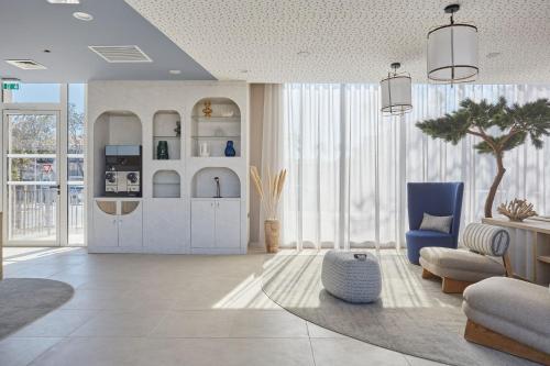 a living room with a blue chair and a couch at Résidence Odalys Riviera in Hyères
