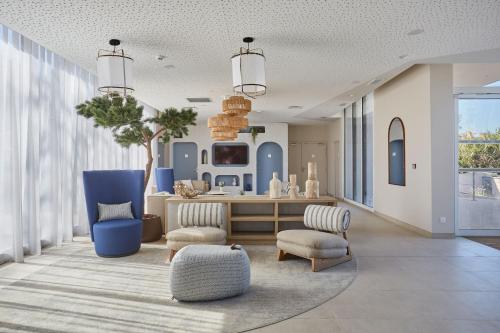 a living room with blue and white furniture at Résidence Odalys Riviera in Hyères