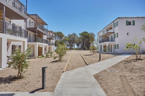 an empty sidewalk in front of a building at Résidence Odalys Riviera in Hyères