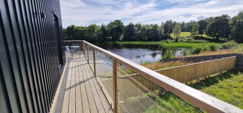 a wooden deck with a view of a river at Otters Cove, Middleton Hall Estate in Belford