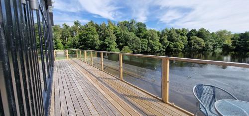 a wooden deck with a view of a river at Otters Cove, Middleton Hall Estate in Belford