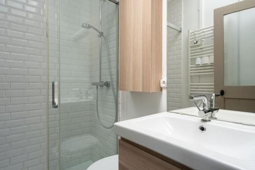 une salle de bain avec un lavabo et une douche en verre dans l'établissement Unique - Appartement avec vue Seine et Tour Eiffel, à Paris