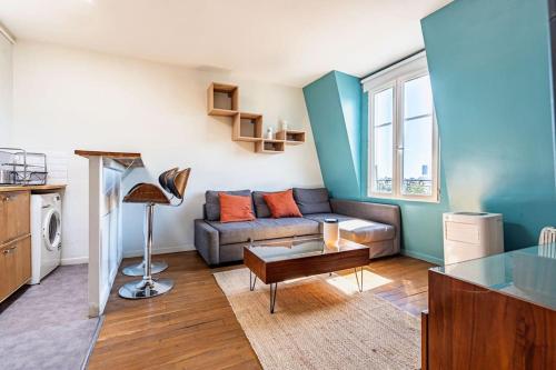 un salon avec un canapé et une table dans l'établissement Unique - Appartement avec vue Seine et Tour Eiffel, à Paris