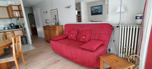 - un canapé rouge dans le salon avec une cuisine dans l'établissement T3 spacious 60 m near the beach of Cannes, à Cannes