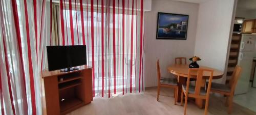 un salon avec une télévision et une table avec des chaises dans l'établissement T3 spacious 60 m near the beach of Cannes, à Cannes