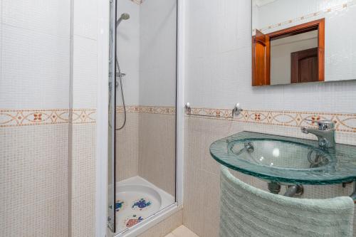 a bathroom with a glass sink and a shower at Casa Verão Azul - Porches in Porches